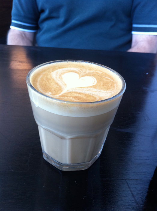 یک فنجان قهوه فلت لایت با طرح قلب روی آن