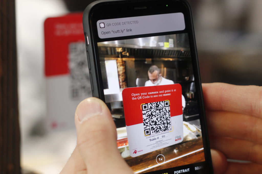 مشتری در حال اسکن کد QR برای دریافت منوی دیجیتال رستوران