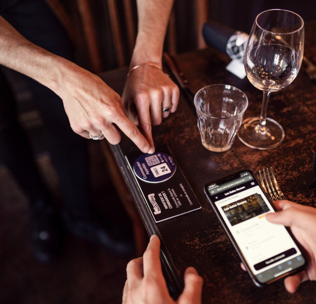 مشتری در حال اسکن منوی دیجیتال با گوشی هوشمند در رستوران