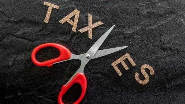 نوشته TAXESروی پس زمینه مشکی و قیچی با مفهوم نرخ صفر مالیاتی